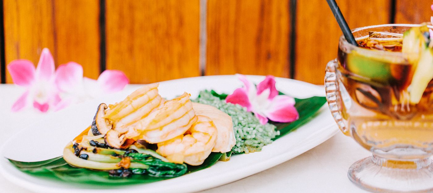 Plated shrimp dish with tropical cocktail