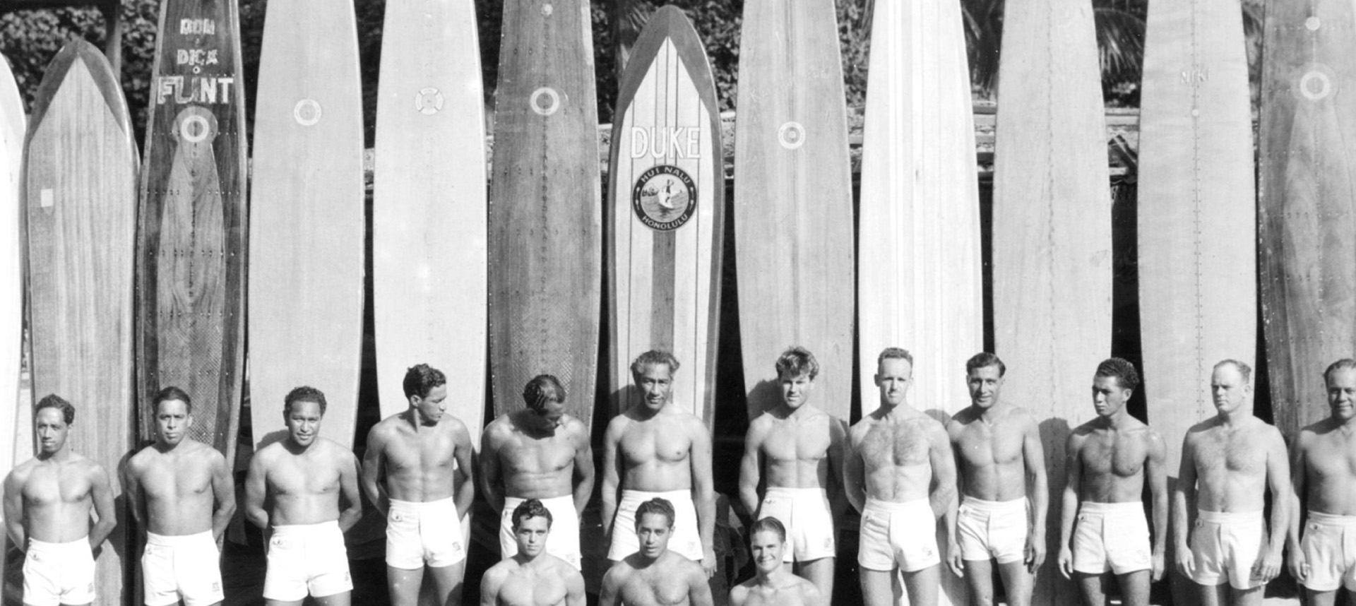 Duke Kahanamoku and the beach boys standing in front of longboards