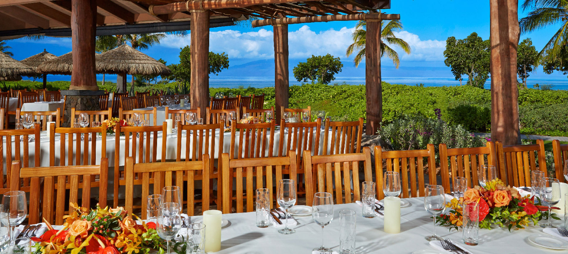 Large dining area with multiple tables in front of the ocean