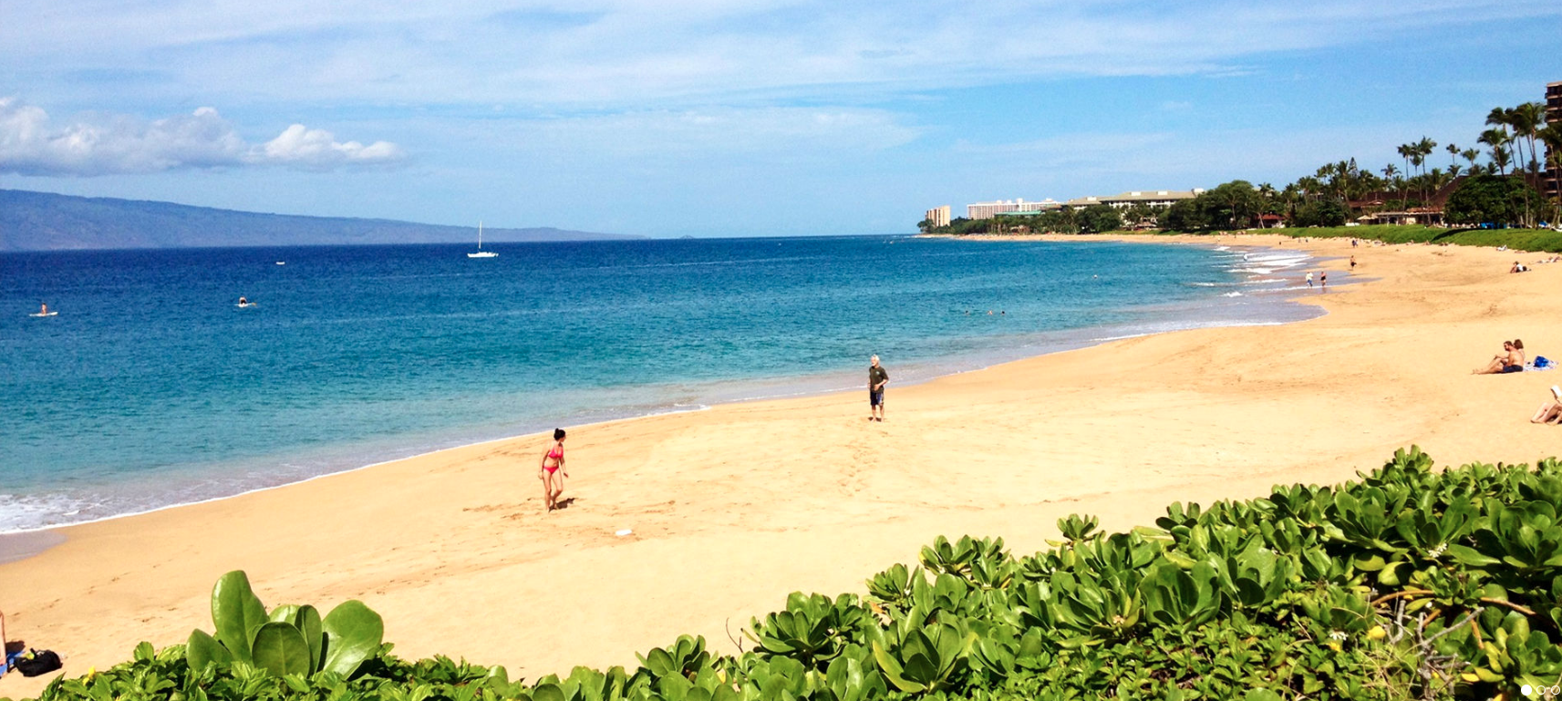 Landscape of ocean with a few people on the shore