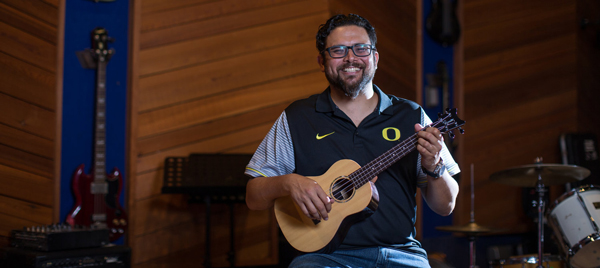 Smiling man holding ukulele